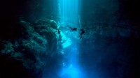 Dos Ojos自然公园里El Pit Cenote的潜水员，墨西哥金塔纳罗奥 (© Christia Vizl/Tandem Stills + Motion)