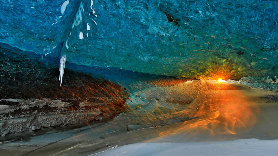 日落时瓦特纳冰川上的冰洞，冰岛 (© Johnathan Ampersand Esper/Aurora Photos)