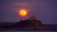 四月的满月从圣迈克尔山上升起，英国康沃尔 (© Simon Maycock/Alamy Live News)